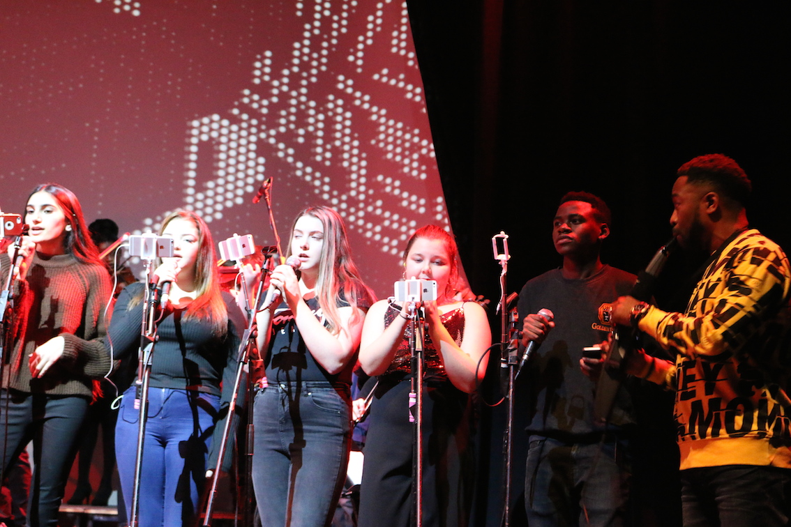Young people singing and playing instruments on stage