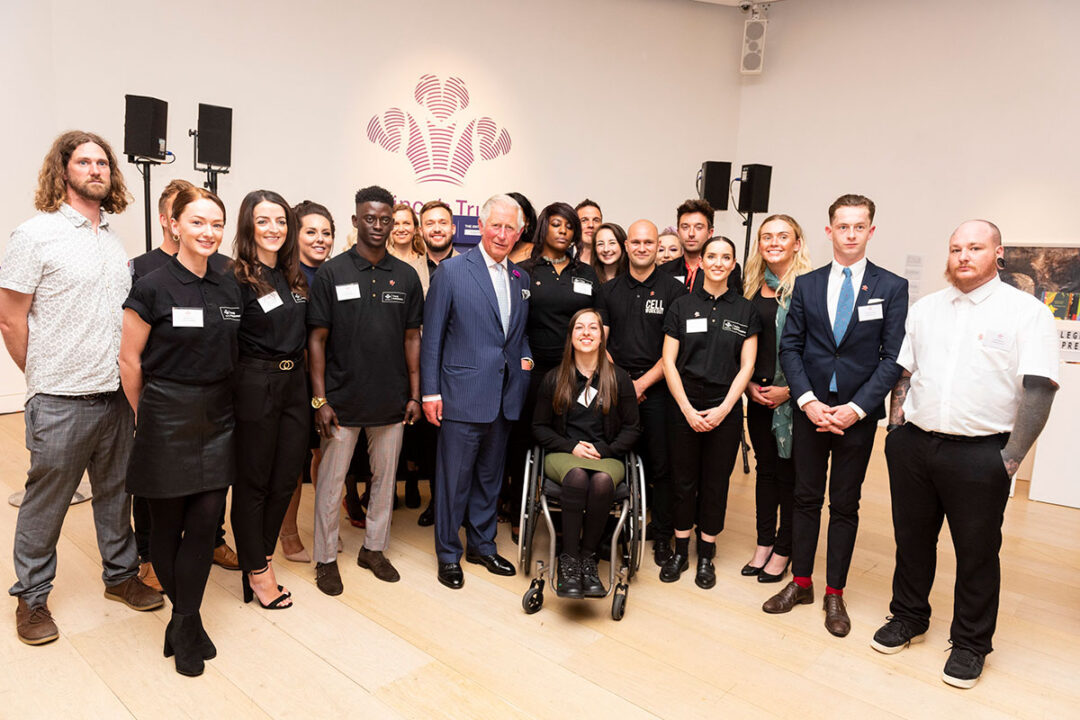 Charles posing with a group of people at the Prince's Trust