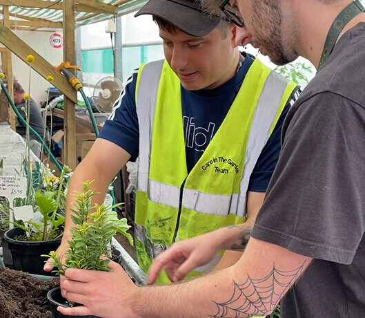 Two people planting pot plants