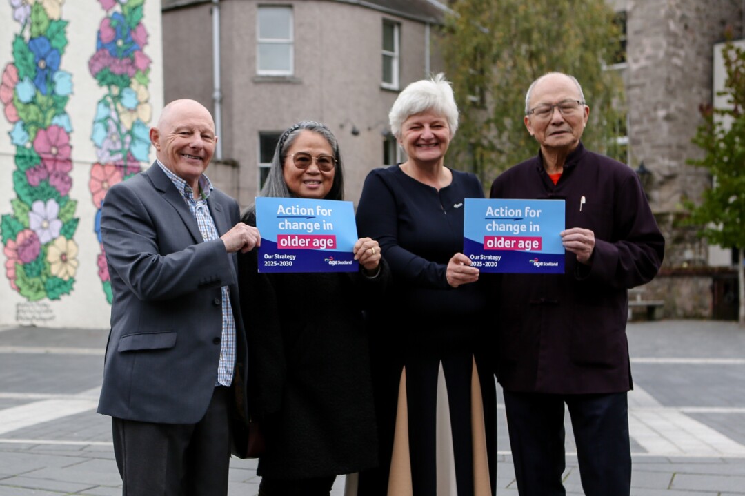 Four older people holding flyers promoting action for change in older age.