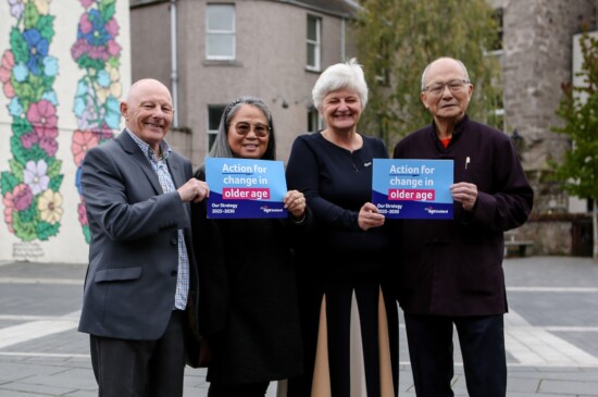 Four older people holding flyers promoting action for change in older age.